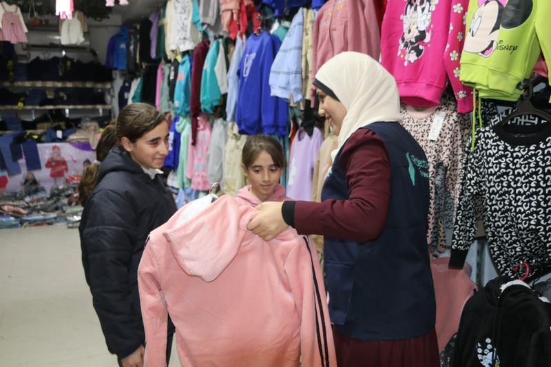 A Project Hope volunteer choosing children's winter clothes