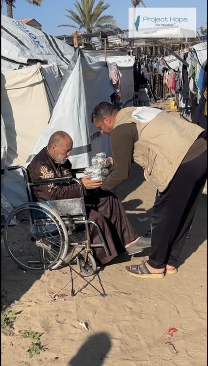A Project Hope volunteer handing food to an elderly man