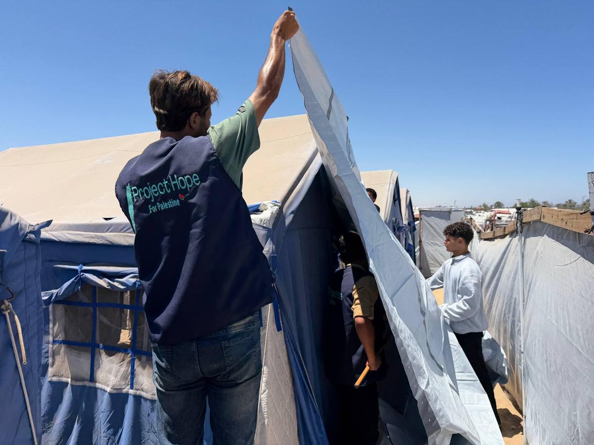 Project Hope volunteers reinforcing tents in a displacement camp